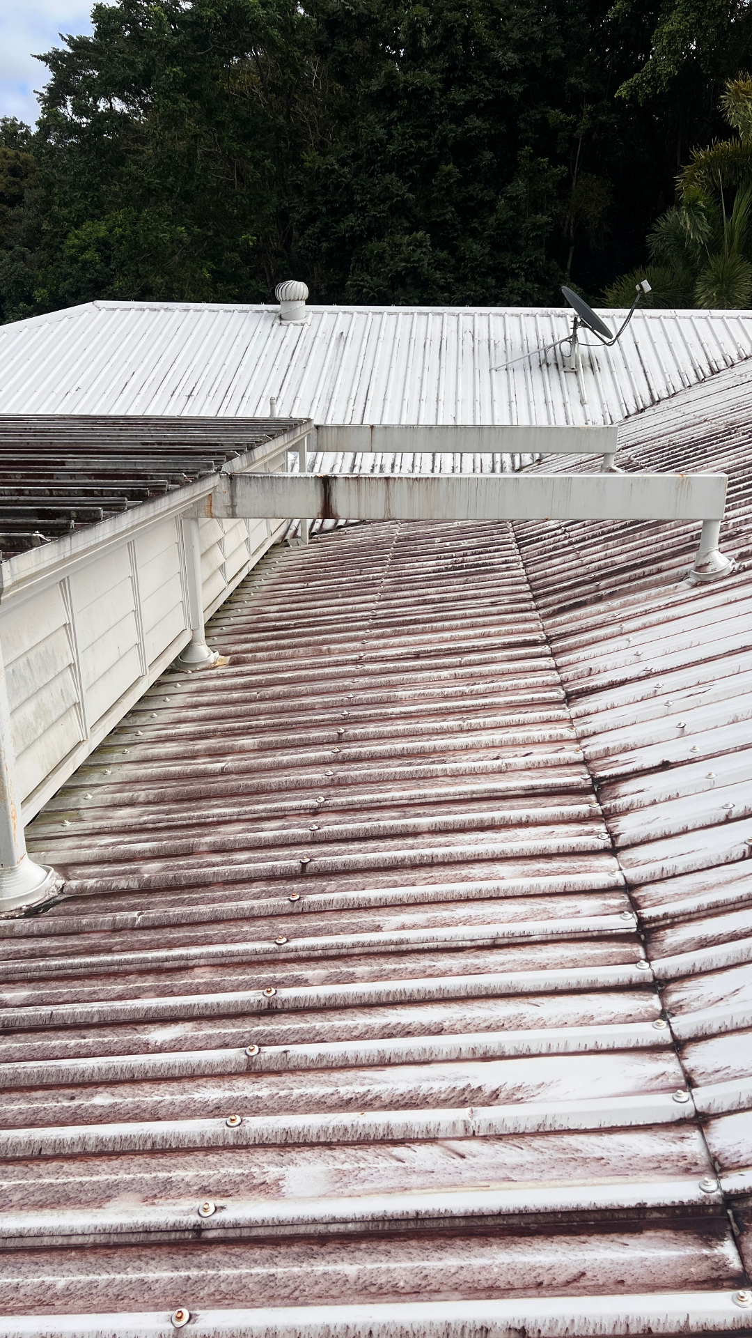 Heavily rust-stained metal roof before cleaning