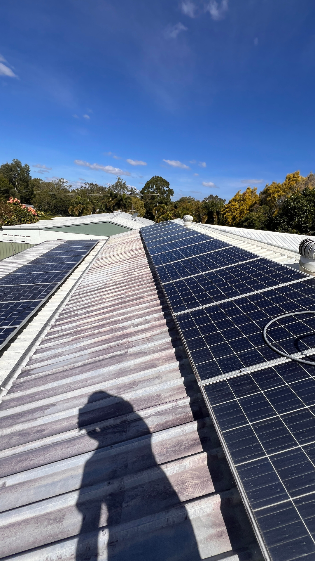 Stained corrugated roof around solar panels before clean