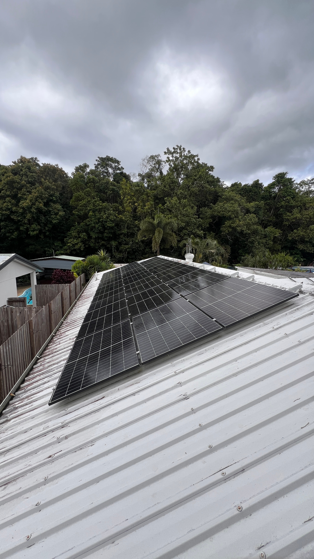 Clean white corrugated roof with solar panels after pressure washing